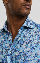 Load image into Gallery viewer, Close-up of a man wearing a blue floral shirt against a neutral background
