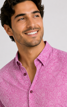 Load image into Gallery viewer, A smiling man wearing a pink button-up shirt with a white abstract swirl pattern, photographed against a light gray studio background.